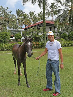 自宅の庭でペットの馬を連れて歩くアニキ