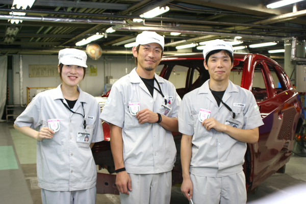 失敗大賞のバッジをつけた車両塗装検査係（左から）佐藤華奈さん、齊藤有希さん、高岡康二さん