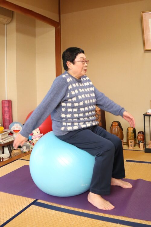 自宅でバランスボールを使って運動する橋田さん（2014年11月）