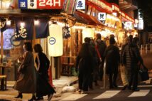 飲食店への営業時間の短縮要請が全面的に解除され、夜を迎えた東京・有楽町の飲食店街を歩く人たち＝10月25日午後、東京都千代田区（時事通信フォト）