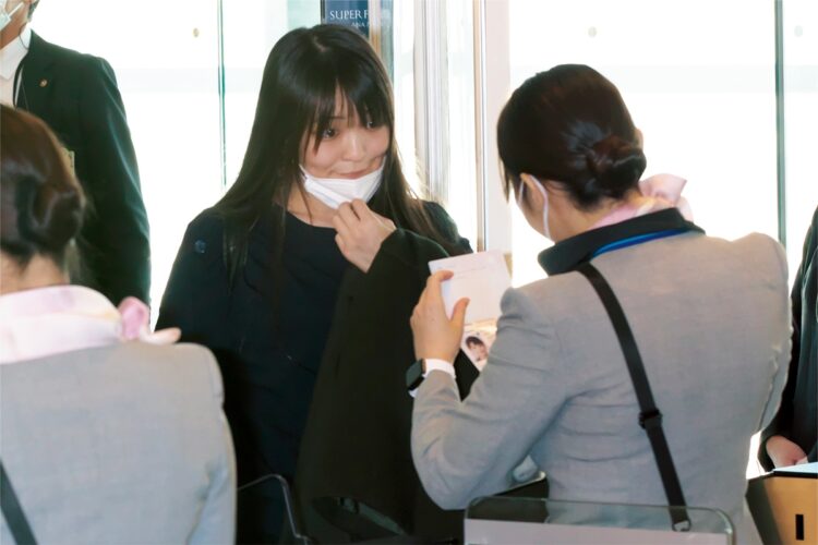 11月14日、空港で機内にチェックインする際、マスクを外して本人確認をする小室さん夫妻