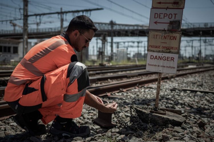 2022年6月15日、前日からの熱波の影響を受け、フランス南西部ボルドーの鉄道駅の外で線路の温度をチェックするフランス国鉄の従業員（AFP＝時事）