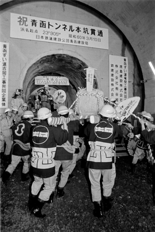 青函トンネルの本坑が貫通し、酒樽神輿を担いで祝う工事関係者。1985年3月10日（時事通信フォト）