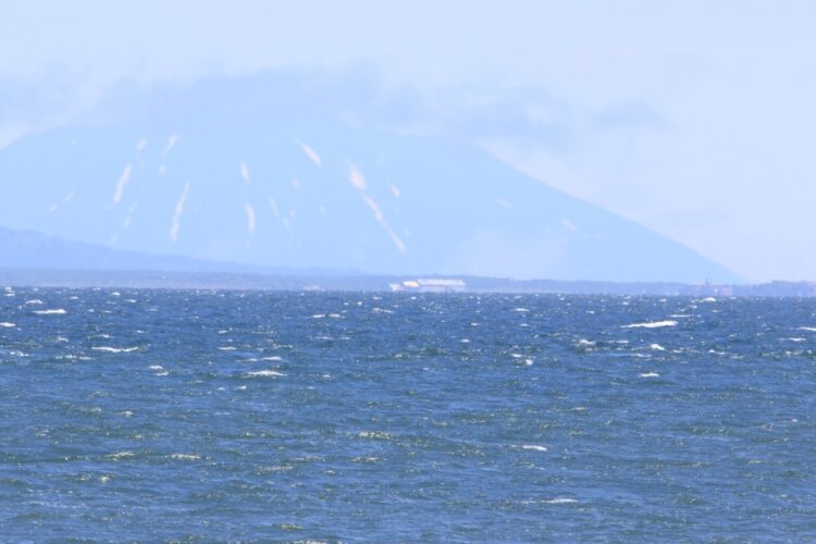 北海道東岸から国後島を撮影。海岸には巨大な建物が見える（撮影／山本皓一）