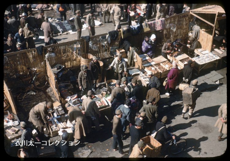 新橋駅前の闇市を収めた数少ない写真。マグロやさつま揚げが売られている。画角から推測すると、新橋駅に停車中の列車から撮られている。おそらく米軍人は立ち入りを禁止されていたのだろう（1946年2月13日、撮影者不明）