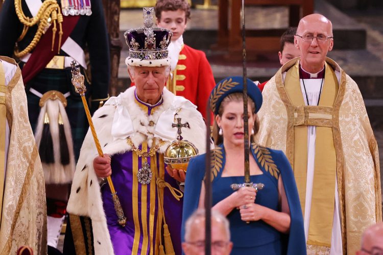 頭上に輝く「聖エドワードの王冠」、携えた宝珠や王笏は王位の象徴として使用される王室宝器「レガリア」と呼ばれる。写真は宝剣を伝達する儀式の様子で、国王の前を歩くペニー・モーダント枢密院議長は女性として初めて剣を持つ役割を果たした（Getty Images）