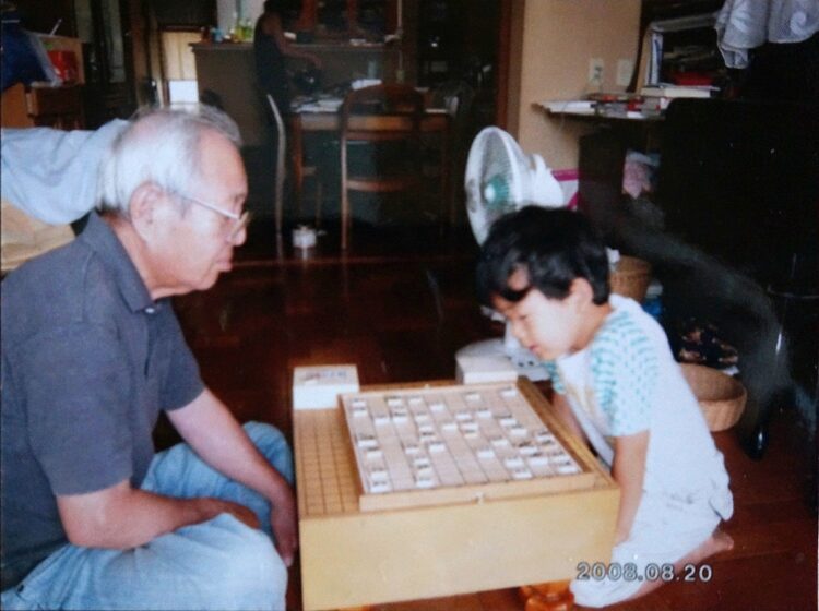 祖父と将棋を指す6才の藤井。毎日のように対局したという（時事通信フォト）