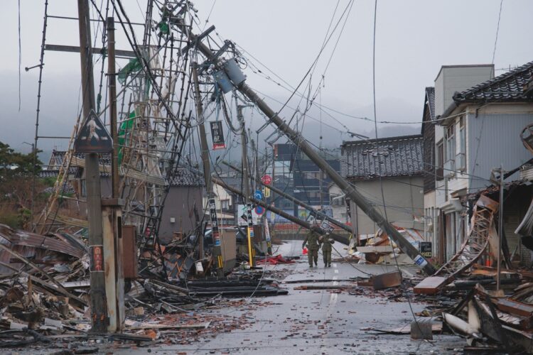 大規模火災で約200棟が燃え、約4万8000平方mが焼失した輪島朝市周辺。傾いた電柱、瓦礫が散乱する中を救出活動に向かう自衛隊員