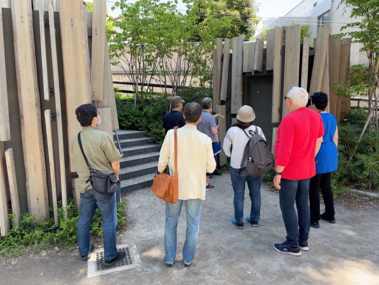 鍋島松濤公園トイレを、ガイドの説明を聞きながら熱心に見学する参加者たち