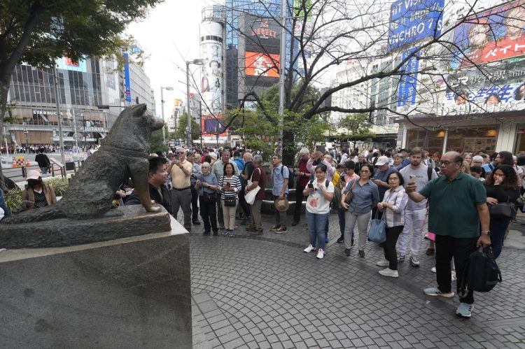 渋谷・ハチ公前で撮影をする外国人観光客（イメージ、時事通信フォト）