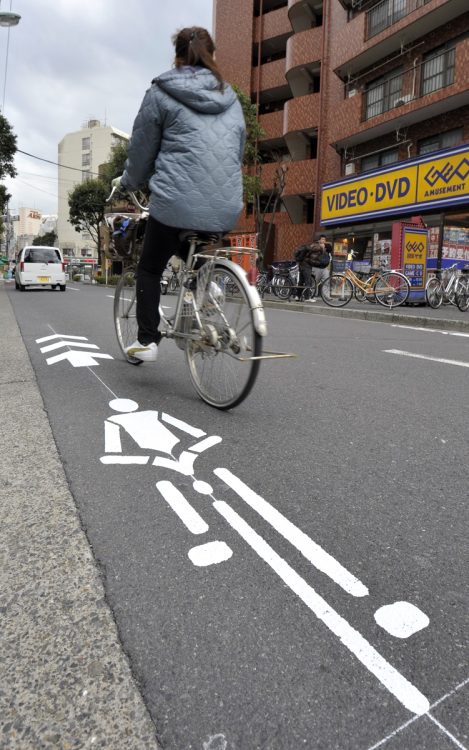 自転車が車道を安全に走れるようにするため、走行ルートを路上に示した「自転車ナビマーク」（時事通信フォト）