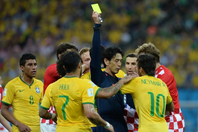 ブラジルのエース・ネイマールに毅然とした態度でイエローカードを提示する西村主審（2014年W杯開幕戦。時事通信フォト）