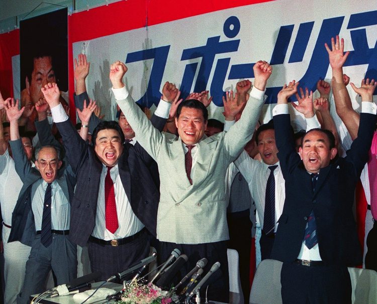 1989年の第15回参院選、ミニ政党のひとつであるスポーツ平和党から比例代表区で初当選し、両手を上げてガッツポーズをするアントニオ猪木さん（中央）（時事通信フォト）