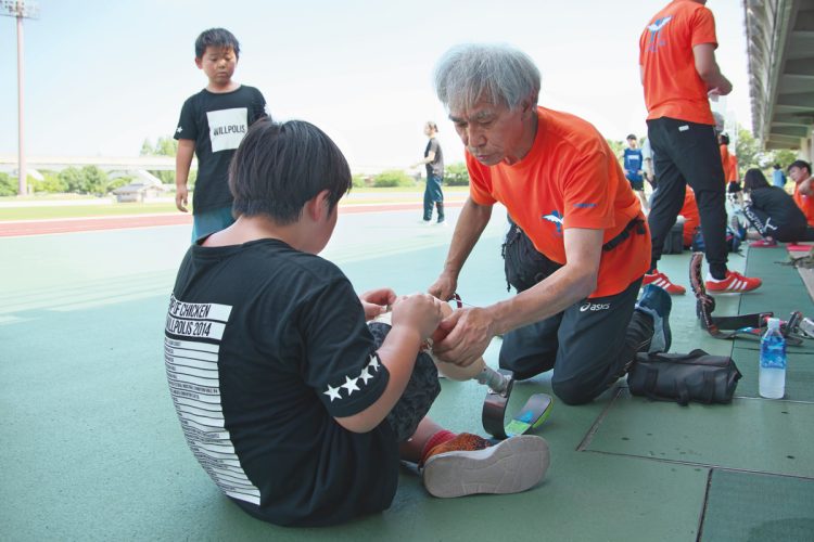 義肢装具士の臼井二美男さんが義足のサポートをする