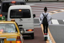 道路を走る電動キックスケーター（時事通信フォト）