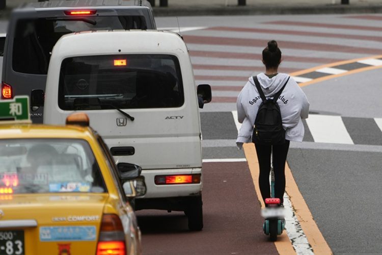 道路を走る電動キックボード（時事通信フォト）