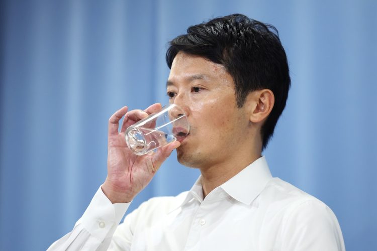 記者会見で水を飲む兵庫県の斎藤元彦知事（時事通信フォト）