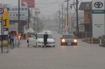 台風10号の影響で、冠水した道路で立ち往生する車両（時事通信フォト）