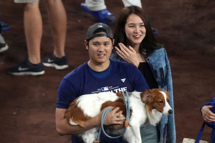 優勝決定後、デコピンを抱きかかえる大谷翔平と真美子夫人（写真：AP/AFLO）