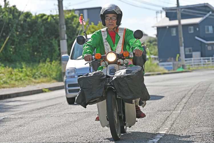 カブを運転しボランティア先まで移動している