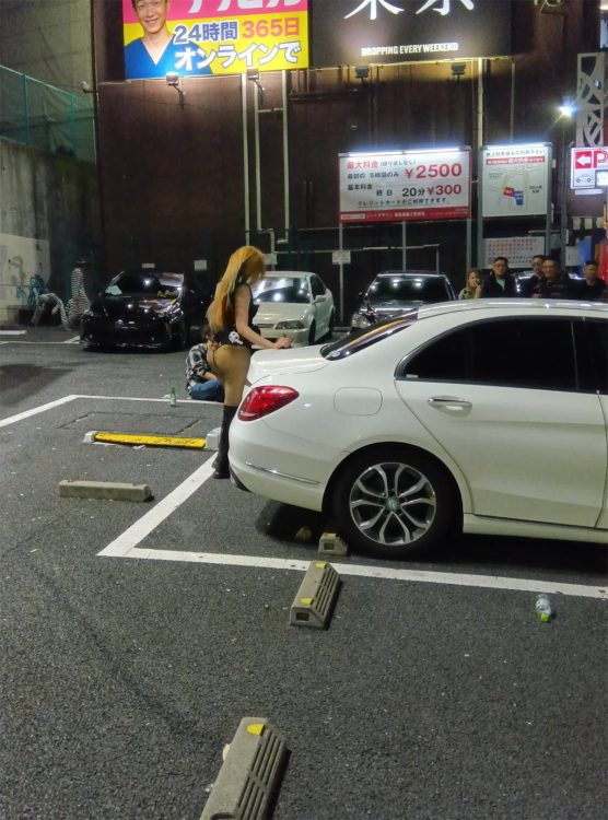 停車中の車にもたれかかっていた