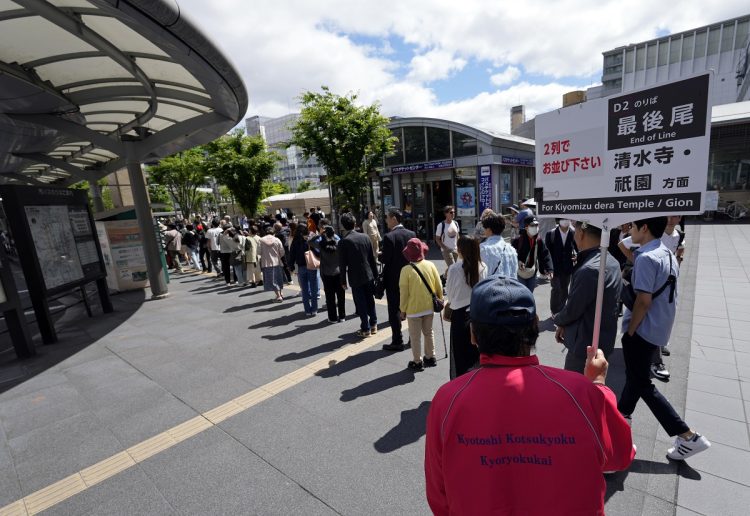 京都駅で祇園地区行きのバス乗り場に長蛇の列。公共交通機関が地域の生活の足としての役割を果たせなくなるほどになっている（EPA＝時事）