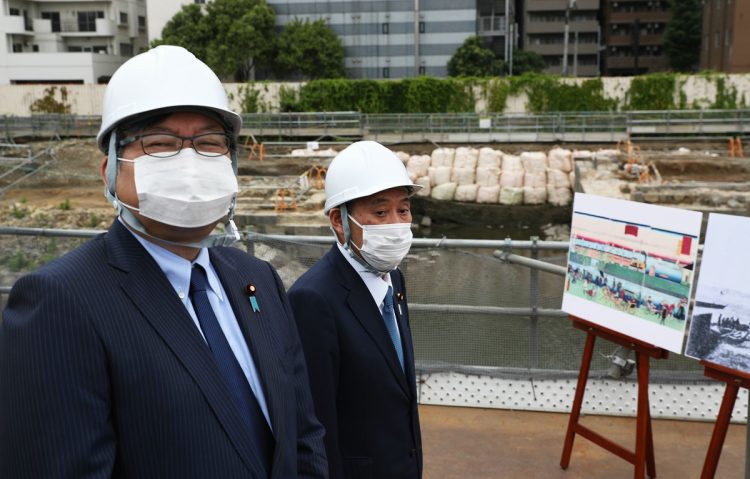 鉄道遺構「高輪築堤」を視察する菅義偉首相（右）と萩生田光一文部科学相（いずれも当時）。2021年5月29日（時事通信フォト）
