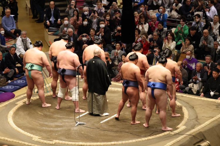 力士たちに向け拍手する着物美人