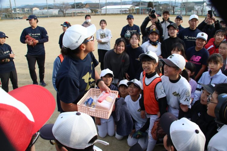 子供たちに金メダルを披露する