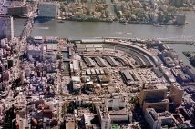 空から見た築地市場（東京中央卸売市場）扇のように独特のカーブを描く外観は鉄道の貨物線路の長さを確保するためだった。1990年11月（時事通信フォト）