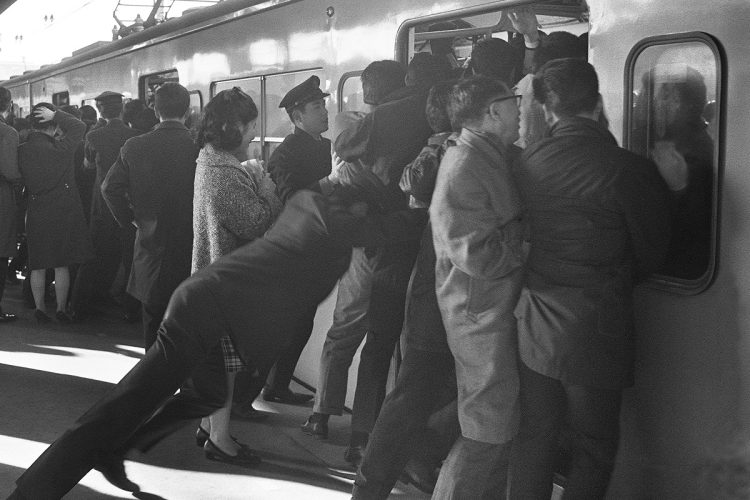 すし詰めの車内に乗客を押し込む国鉄職員＝国鉄新宿駅（1967年12月、時事通信フォト）