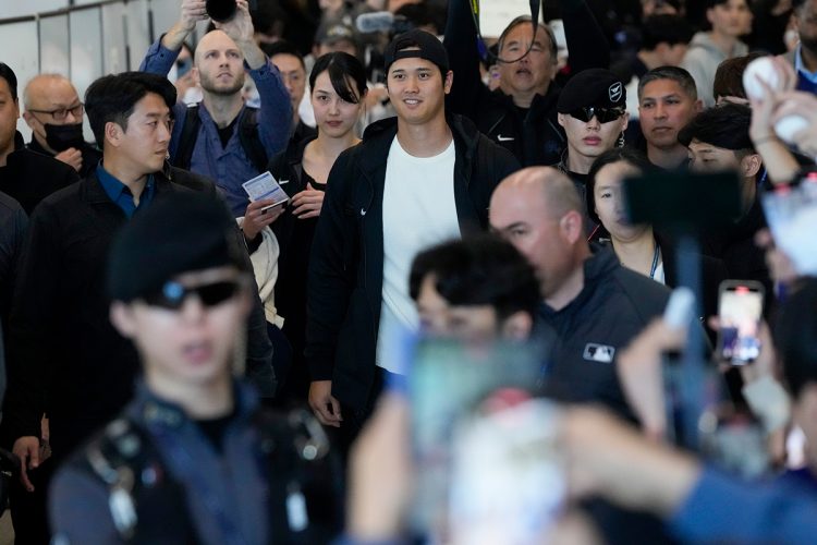 空港で大勢に囲まれる大谷翔平と真美子夫人（写真／アフロ）