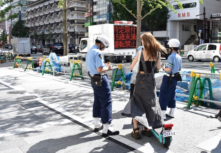 電動キックボードの違反を取り締まる警察官（時事通信フォト）